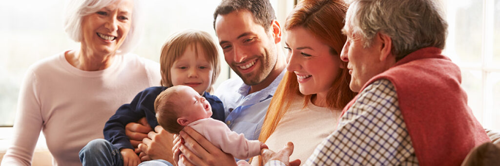 family smiling and looking at new baby