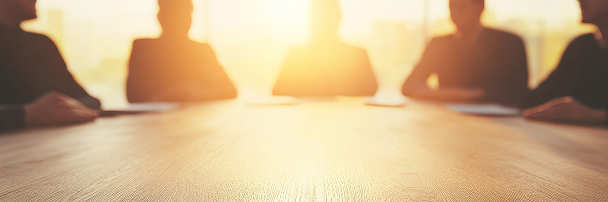 Collaborative Law is also an alternative dispute resolution method. Picture of silhouetted people sitting around an office desk.